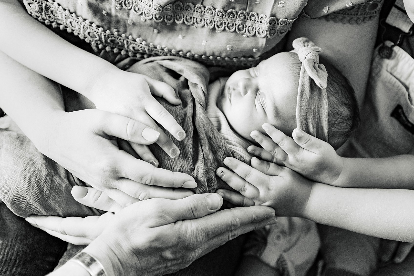 Childrens hand on baby during photoshoot at home black and white newborn photo ideas